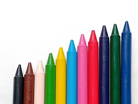 Multi coloured crayons placed on a white background. Close -up shot of the crayons.