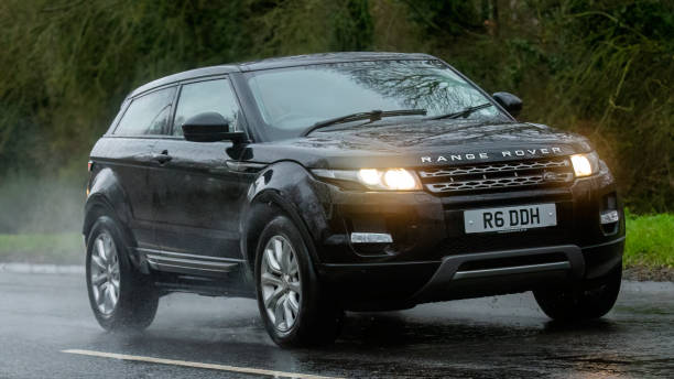 Range Rover Evoque Milton Keynes,Bucks,UK - Dec 9th 2023: 2014 diesel engine Range Rover Evoque car driving on a wet road, in the rain with headlights on evoque stock pictures, royalty-free photos & images