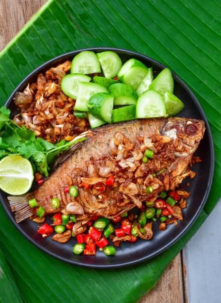 istock fried fish,Garlic fried fish,pikled fish, top view food table, With side vegetables  dishes, thai call pla som tod 1842277090