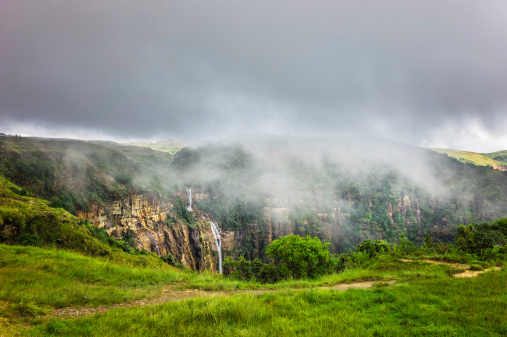 Storm clouds gather over the Khasi Hills with waterfall and high granite rock slopes and deep gorges near Cherrapunjee. Meghalaya, India.