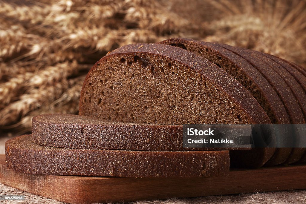 Loaf of bread and rye ears still life Loaf of bread and rye ears still life on rustic background Abundance Stock Photo