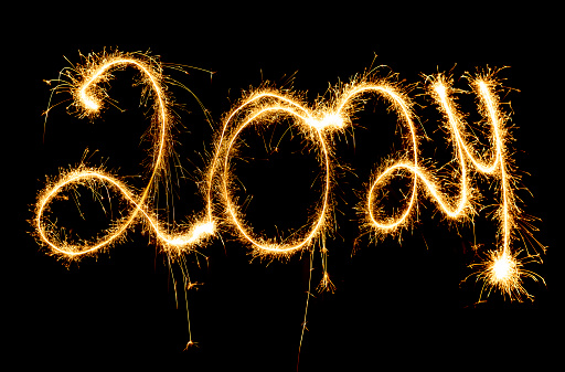 The year 2024 written with sparklers on black background