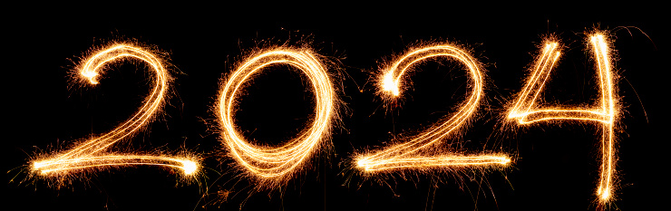 The year 2024 written with sparklers on black background