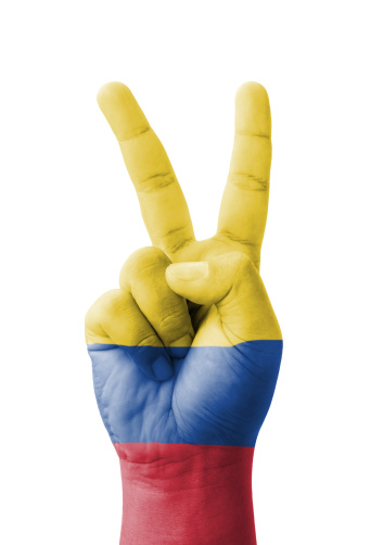 Hand making the V sign, Colombia flag painted as symbol of victory, win, success - isolated on white background