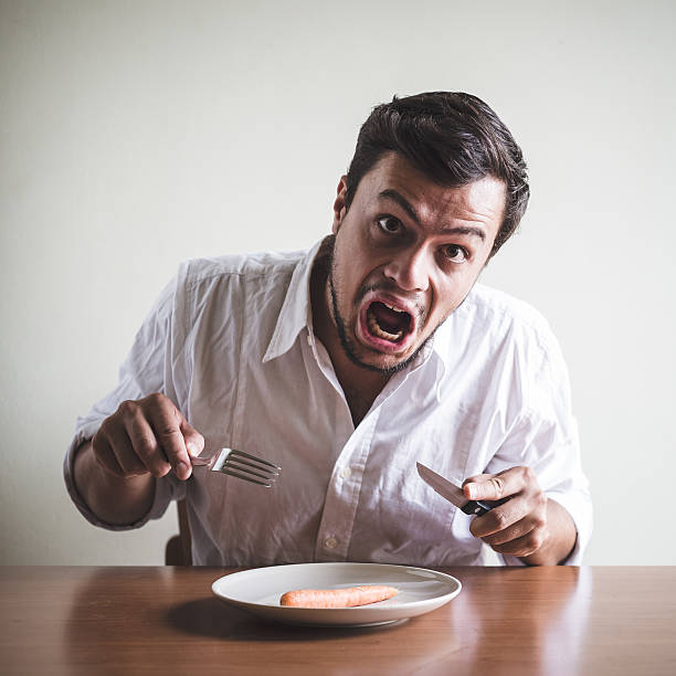 istock young stylish man with white shirt eating carrot 184233580