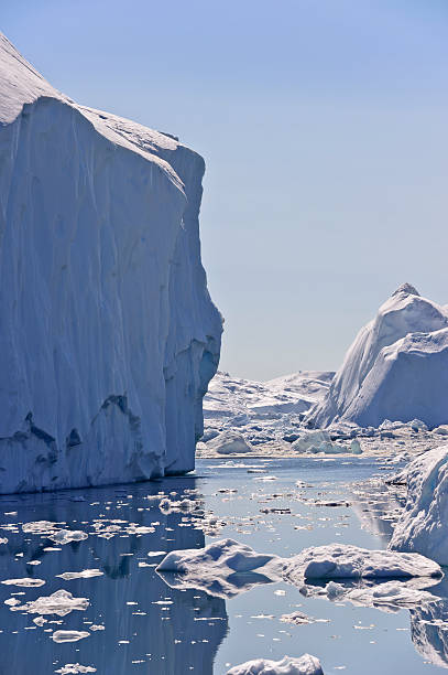 Huge iceberg in the Jacobshavn icefjord, Greenland These icebergs are calved by the Jakobshavn glacier, and may stay in the icefjord for years, before floating North with the currents, eventually turning south and down into the Atlantic ocean. They usually range in height from 1 to 75 meters. The air in the glacial ice of an iceberg is under great pressure, and crackles and pops as it melts giving rise to the term Bergie Seltzer. ilulissat icefjord stock pictures, royalty-free photos & images