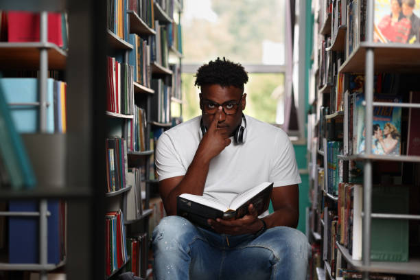 istock Cute student in glasses with serious look studying new book 1842362328