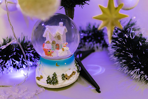 Stylish Christmas decoration and ornaments. Happy New Year background. Christmas snow globe.