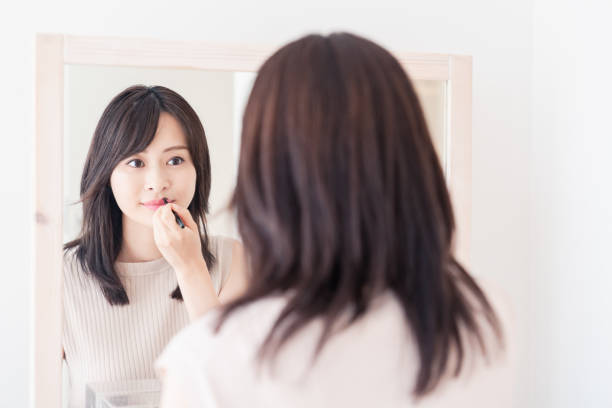 istock Young woman applying makeup at home 1842377092