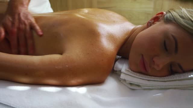 beautiful young woman gets pleasure from wellness procedures in spa.