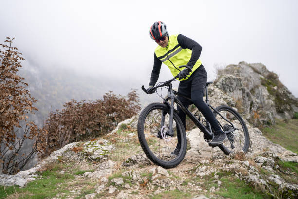 istock Mountain biker descends rock ridge from summit 1842433443