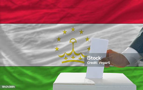 Hombre De Voto En Las Elecciones En Tayikistán Front Of Flag Foto de stock y más banco de imágenes de Adulto