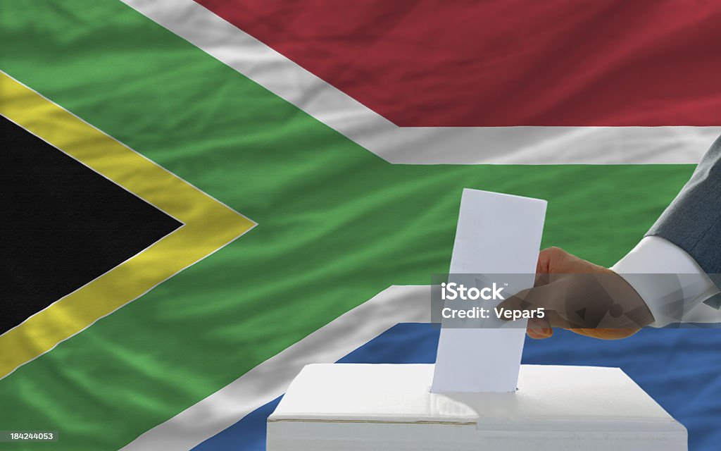 Hombre de voto en las elecciones en Sudáfrica front of flag - Foto de stock de Adulto libre de derechos