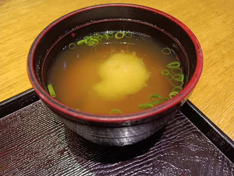Japanese miso soup, containing miso paste  (from fermented soybean) dissolved below boiling point to maintain active probiotics benefits. Tofu, seaweed and sliced shallot are added.