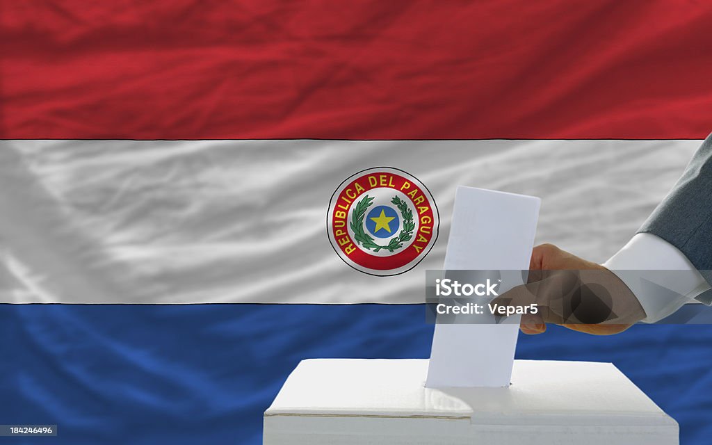 Uomo di voto sulle elezioni in paraguay davanti bandiera - Foto stock royalty-free di Adulto