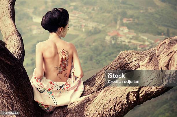 Woman With Snake Tattoo On The Tree Branch Stock Photo - Download Image Now - Tattoo, Back, Rear View