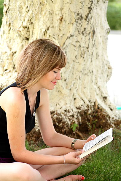 istock Beautiful long haired brunette female student  with book 184248526