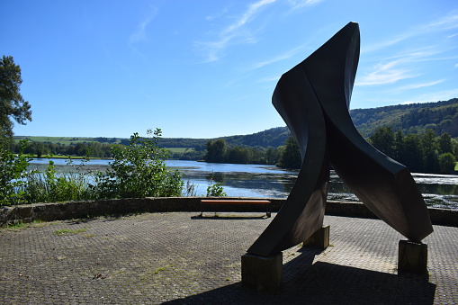 Echternach, Luxembourg - 09/26/2023: park at the lake with a park bench and a sculpture