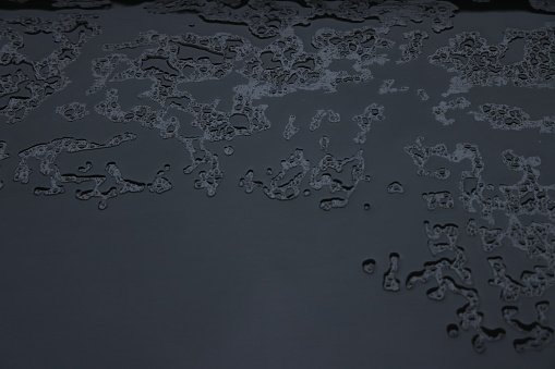 Black background with raindrops and puddles