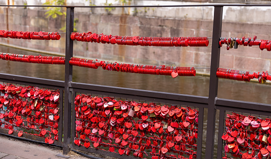 Love locks, in red, on the fence by the Lauch river in Colmar, France