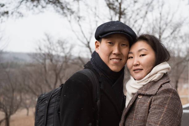 istock happy young asian couple walking outdoors in winter park 1842570110