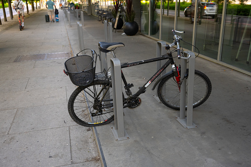Valencia, Spain - September 3, 2021: Bicycle hooked to pole with missing rear wheel. Most likely the owner left it there and took the wheels to fix it