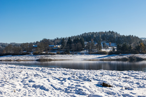 Lake Lavalette surrounded by a fir forest in the Gorges du Lignon, under the first snows of winter