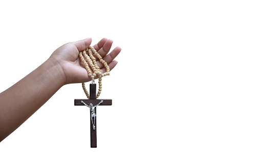 Wooden cross holding in hands of old prayer isolated on white background with clipping paths.