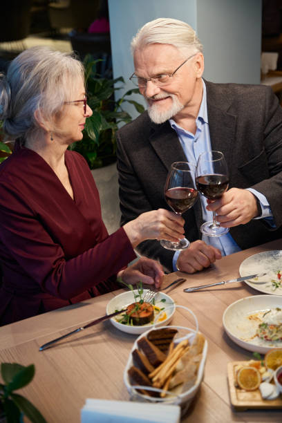 istock Aged man and woman clinking glasses with wine while celebrating Christmas 1842626989