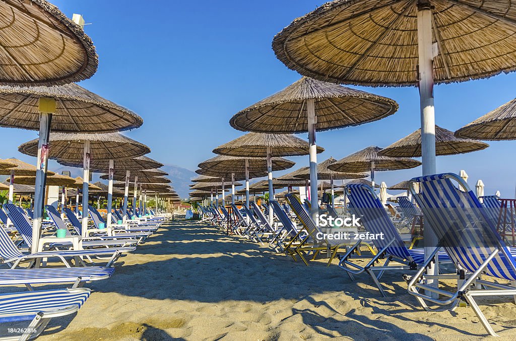 Liegestuhl und Sonnenschirm am Sandstrand. - Lizenzfrei Blau Stock-Foto