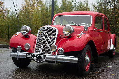 Mulhouse - France - 12 November 2023 - Front view of red Citroen traction parked in the street by rainy day