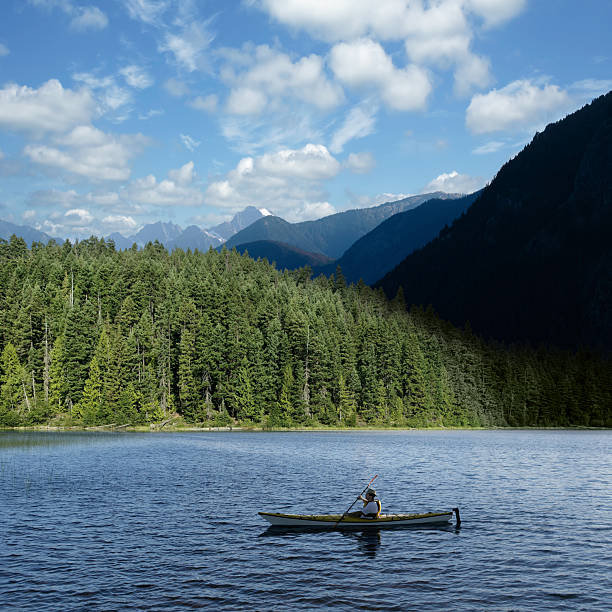 Canoe in a lake surrounded by mountains at sunset.