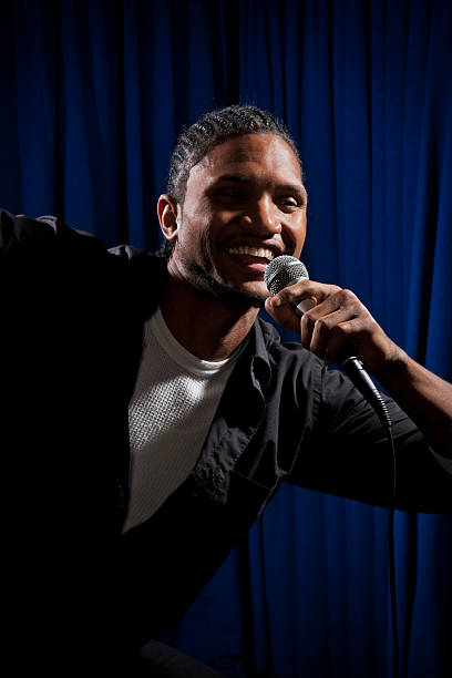 istock Portrait of a young man with microphone on stage 184265426
