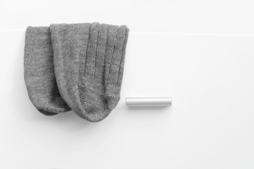 Grey wool socks hanging out of the white drawer.