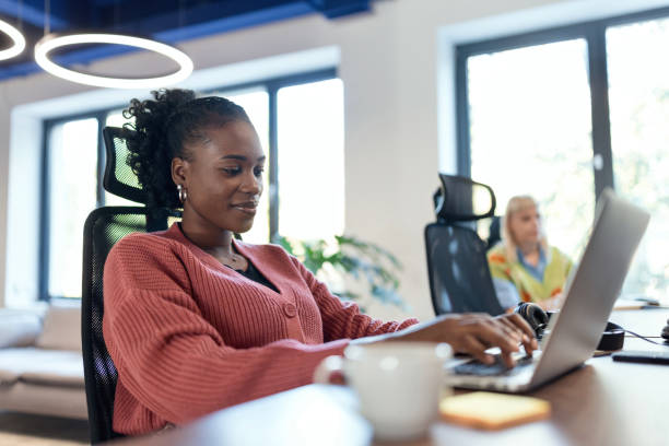 istock Smiling woman coding on her laptop in the modern working space 1842656751