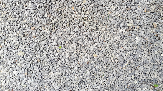 Close-up detail of small pebbles creating a textured pattern on a gravel road.