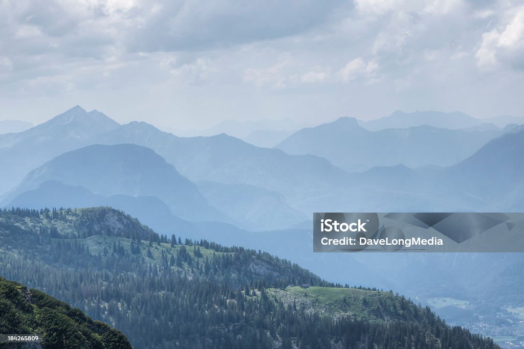 Alpine Scenic View of the Bavarian Alps from atop the Untersberg mountain (1,972 m), which straddles the boarder between Germany and Austria. A high-alpine farm house can be seen in the pasture in the near distance. Aerial View Stock Photo