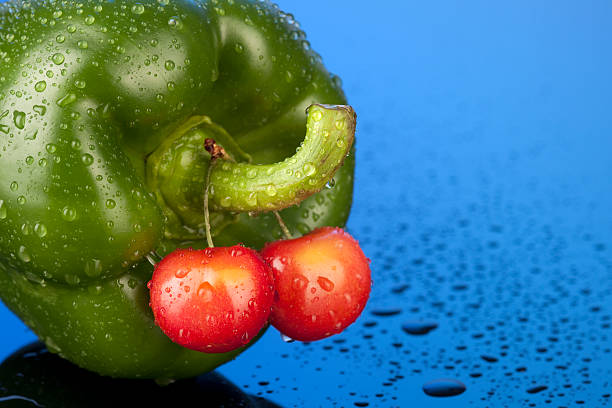 Wet Green Pepper With Bing Cherries Wet Green Pepper With Bing Cherries testis stock pictures, royalty-free photos & images