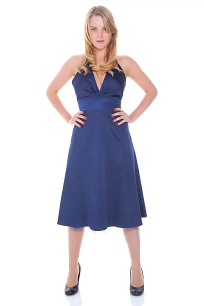 Studio shot of a teenage girl standing in a blue ballgown with her arms akimbo - isolated on white.