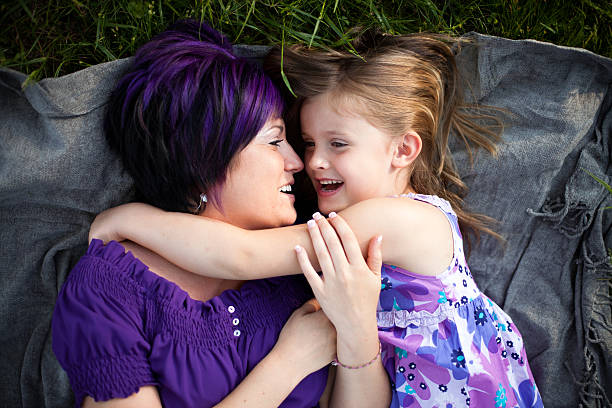 istock Mother and Daughter Laying in Grass Together 184266482