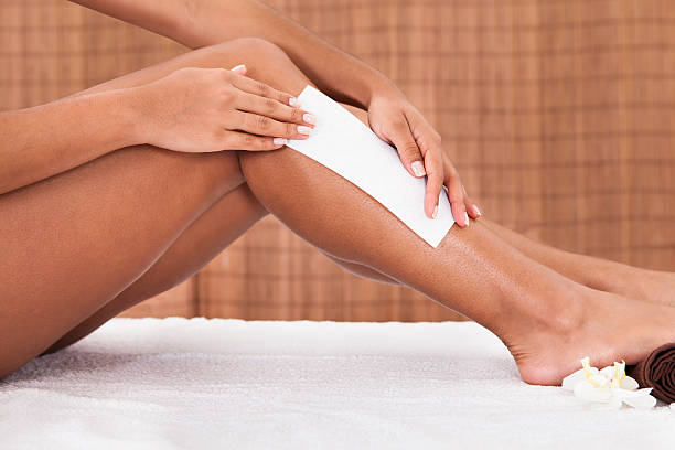jovem mulher dando depilação nas pernas - beautician beauty treatment smooth human leg imagens e fotografias de stock