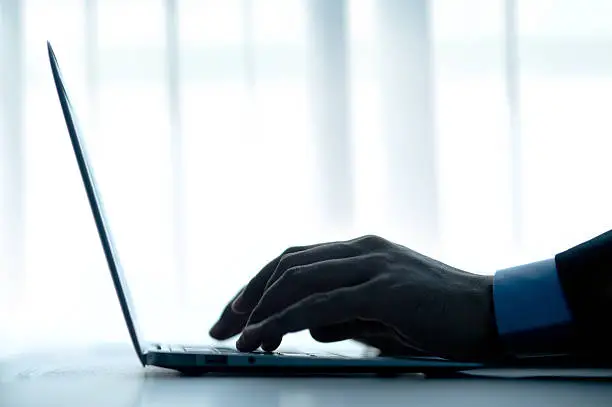 Photo of Businessman typing a computer.