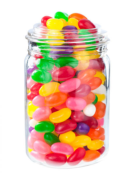 Jelly beans in a jar Jellybean sugar candy snack isolated on white jellybean stock pictures, royalty-free photos & images