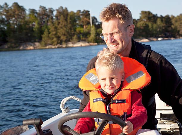 istock Father and son steering small boat in Stockholm Archipelago 184268069