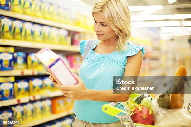 Mujer Haciendo Compras De Cereales Foto de stock y más banco de imágenes de Cereal de desayuno - Cereal de desayuno, Etiqueta, Adulto