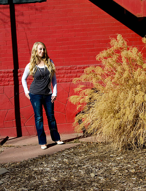 istock Young woman standing by a red wall 184270446
