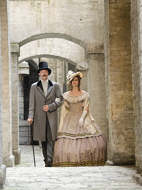 istock Couple in Victorian costume walking through stone corridor 184270478