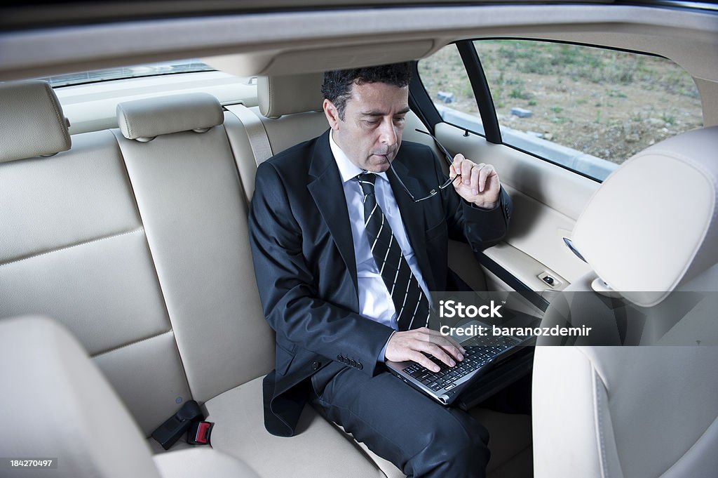 Uomo d'affari che lavorano all'interno di un'auto - Foto stock royalty-free di Adulto