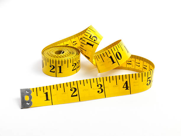 Tape measure in yellow measuring in inches yellow tape measure isolated on white tape measure photos stock pictures, royalty-free photos & images