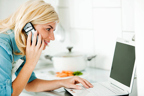 istock Beautiful woman talking on the mobile and using laptop. 184271482